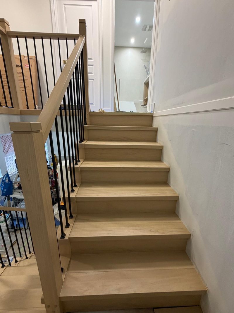 Finished staircase with oak treads and black metal balusters, Surrey